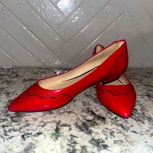 Red Nine West flats with black piping, size 7.